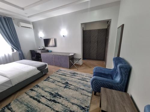 MaiduguriSolace Suites and Homes Maiduguri的一间卧室配有一张床、一把椅子和一张书桌