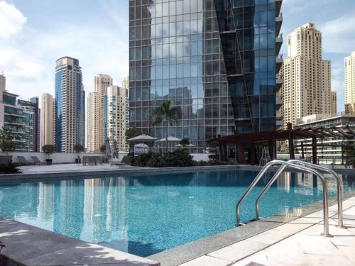 迪拜LUX Holiday Home Dubai Marina JBR - Silverene Tower Studios的一座位于城市的游泳池,有高大的建筑