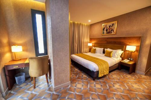 奥兰LE PALME HOTEL的配有一张床和一张书桌的酒店客房