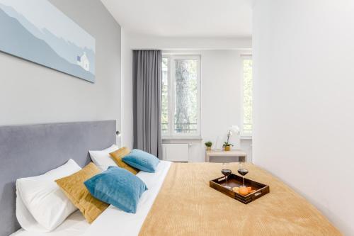 华沙Warsaw City Apartments EXPO的白色卧室配有一张带蓝色枕头的大床