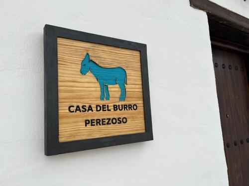 AlmácharCasa del Burro Perezoso的墙上的标志,上面有马