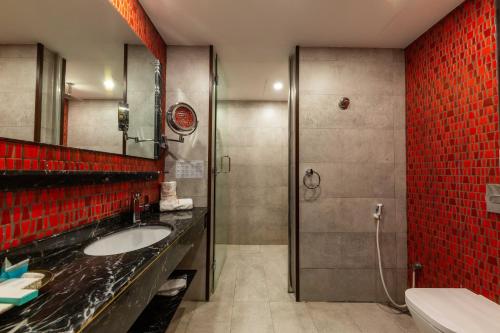 延布فندق روزالينا的浴室设有水槽和红色瓷砖淋浴。