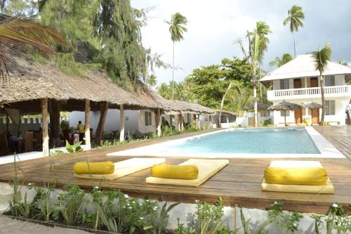 帕杰Mem Luxury Apartments and Hotel的度假村的游泳池,在木甲板上设有黄色枕头