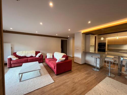 美贝尔Newly renovated 7-9pers Luxury Chalet in Meribel Centre 85m2 3BR 3BA with stunning Mountain View的一间带两张红色沙发的客厅和一间厨房
