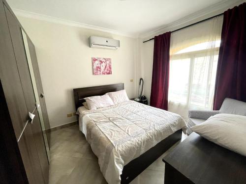 艾因苏赫纳Spacious Penthouse Chalet at Telal Sokhna的卧室配有床、椅子和窗户。