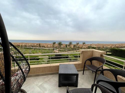 艾因苏赫纳Spacious Penthouse Chalet at Telal Sokhna的阳台配有椅子,享有海景。
