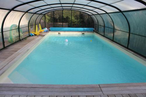 Frasnes-lez-AnvaingEntre mare et chêne的一座带温室的室内游泳池