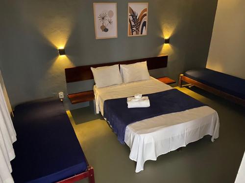 里约达欧特拉斯Pousada Puerta Del Sol Rio das Ostras的一间卧室配有一张带蓝白色毯子的床