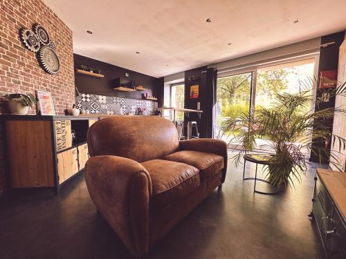 Dompierre-sur-HelpeLe loft的客厅设有棕色椅子和砖墙