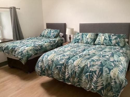 基拉尼Rose Cottage的一间卧室配有一张床和一张棕榈叶床罩