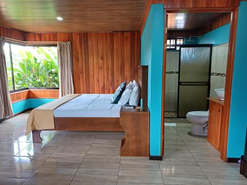 福尔图纳Cabañas Sueños del Arenal的一间卧室配有一张床,浴室设有卫生间