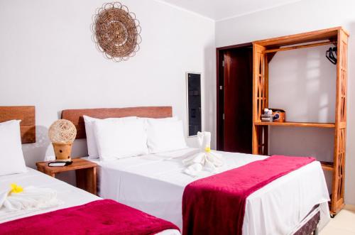 圣米格尔-杜斯米拉格里斯Pousada Chalés do Toque的一间卧室配有两张床和镜子