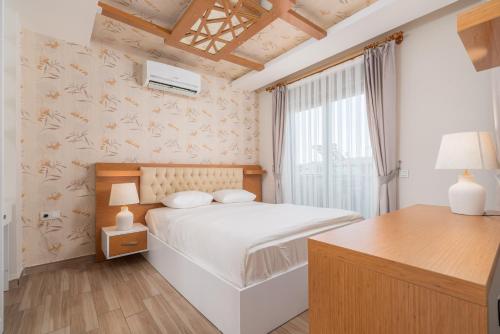 安塔利亚Loi Suite的卧室配有白色的床和窗户。