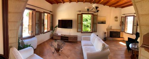 罗德镇Suite del Capitano的客厅配有白色家具和电视