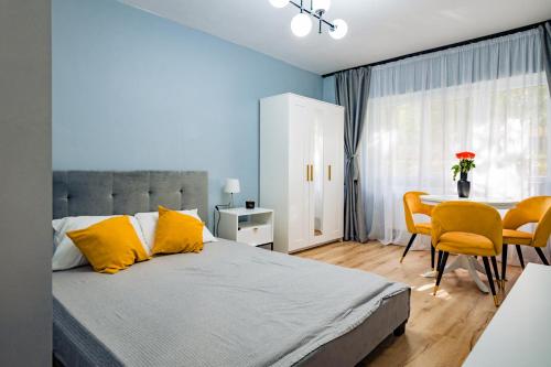 札勒乌Modern studio D-va N的一间卧室配有一张带黄色枕头和桌子的床