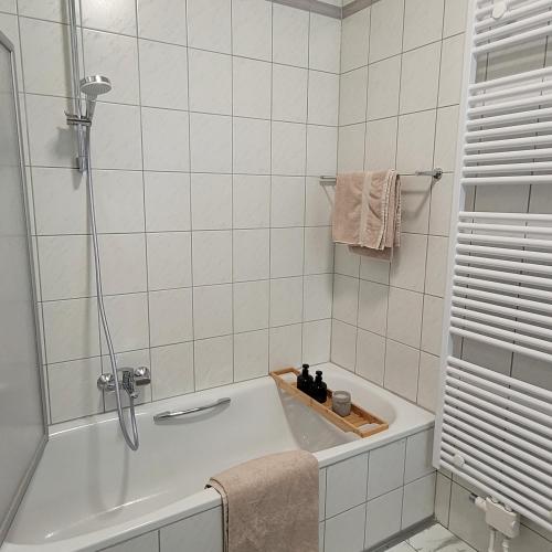 瓦尔堡Ferienwohnung an der Stadtmauer的白色的浴室设有浴缸和淋浴。