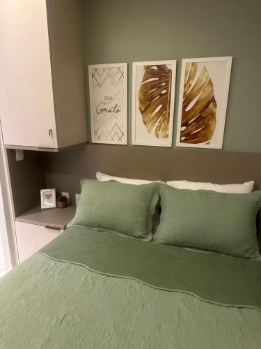 塔曼达雷Flat praia dos carneiros eco resort 26的卧室配有一张四幅画的墙壁床。