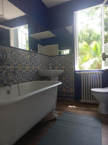 阿维尼翁Le Nid的带浴缸、两个盥洗盆和窗户的浴室