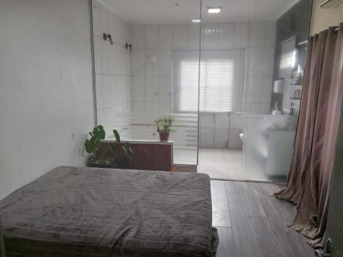 佩洛塔斯Pousada VIDA的一间卧室配有一张床,浴室设有淋浴。