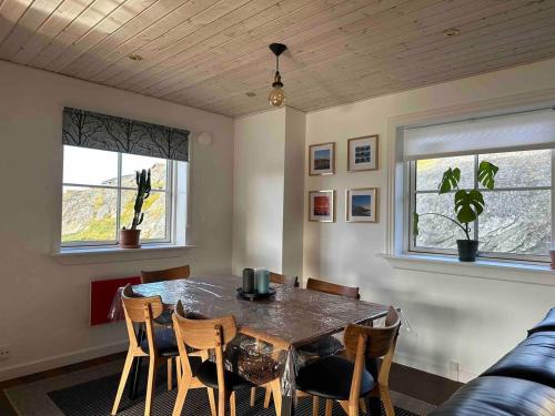 努克Nuuk Villa Hostel的一间带桌椅和2扇窗户的用餐室