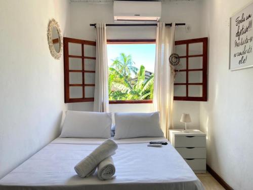 帕拉蒂Casa Aconchego 5min do centro histórico e praia的卧室配有白色的床和窗户