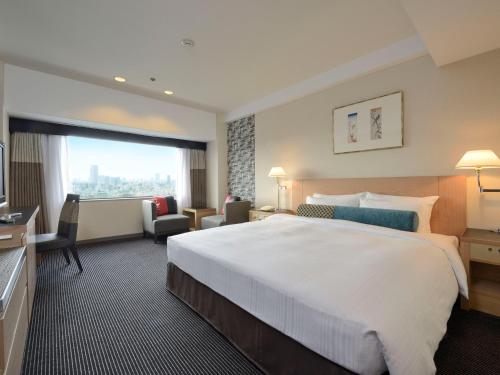 东京东京新大谷酒店花园塔酒店的一间酒店客房,设有一张大床和一个大窗户