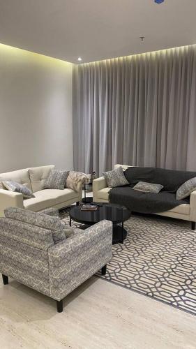利雅德Luxury Apartment的带沙发、桌子和窗帘的客厅