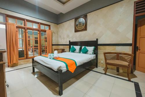 日惹Homestay Simply Homy Jogja dekat Gembira Loka Zoo的一间卧室配有一张床和一把椅子