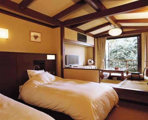 奈良春日酒店的一间卧室设有两张床和大窗户