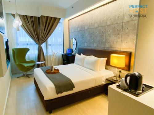 八打灵再也Centrestage Petaling Jaya by Perfect Host的配有一张床和一把椅子的酒店客房