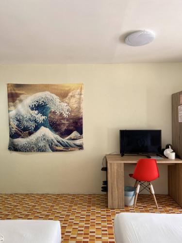 芭东海滩Baankasemsuk Resort 般咔 深宿的墙上有一幅波浪画的房间