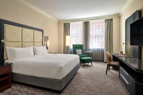 芝加哥芝加哥JW万豪酒店的酒店客房,配有一张床和一把绿色椅子