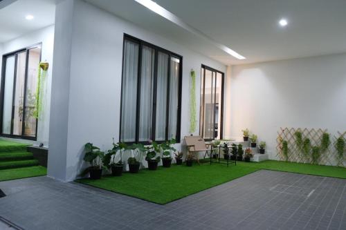 曼谷雪梨的民宿：Sukumvit 36的一间种植了植物和绿色地毯的客厅