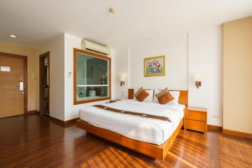 曼谷Lantana Resort Hotel Bangkok的一间卧室设有一张大床和大窗户