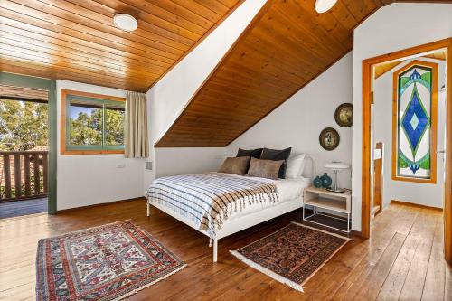罗什平纳THE HOUSE ROSH PINA - 2BRM WITH POOl的一间卧室设有一张床和木制天花板