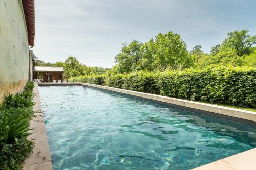 Saint-Paterne-RacanGîte des Ecuries d'Hodebert的庭院里的一个蓝色海水游泳池