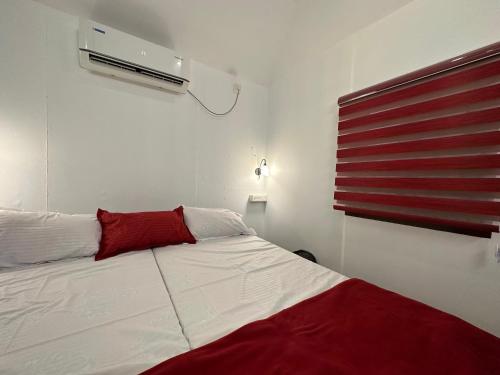 马拉利库兰Coastal Cabana Marari的卧室配有白色的床和红色枕头