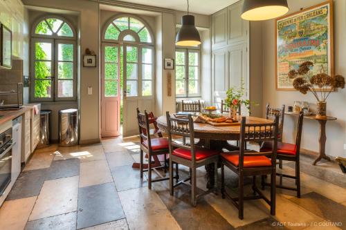 Saint-Paterne-RacanGîte des Ecuries d'Hodebert的厨房配有餐桌和椅子