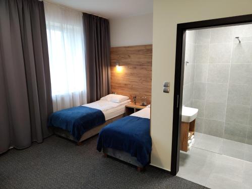 凯尔采S7 Hotel的酒店客房设有两张床和淋浴。