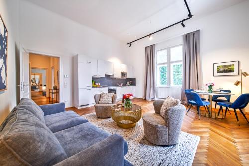 多瑙河畔克雷姆斯Smile Apartments am Stadtpark的客厅配有沙发、椅子和桌子