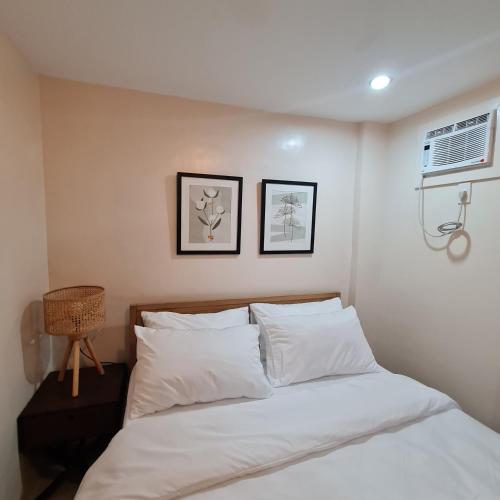 塔比拉兰Urban Homes Bohol的卧室内的一张床铺,墙上有两张照片