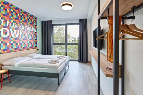 科隆MEININGER Hotel Köln West的一间卧室设有一张床和一个大窗户