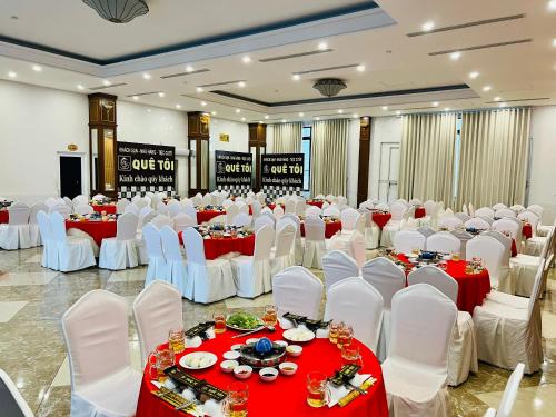 朔庄Quê Tôi 2 Hotel的宴会厅配有红色和白色的桌椅