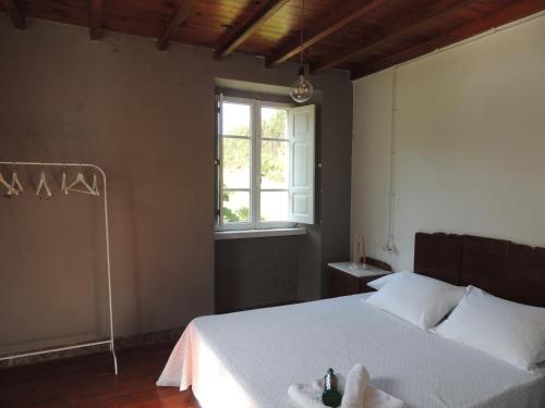 福斯Casa de Campo Pumarada de Oirín的卧室配有白色的床和窗户