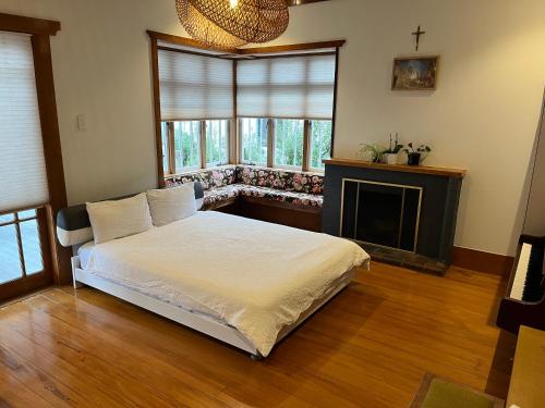 奥克兰Bayswater Homestay的卧室配有白色的床和壁炉