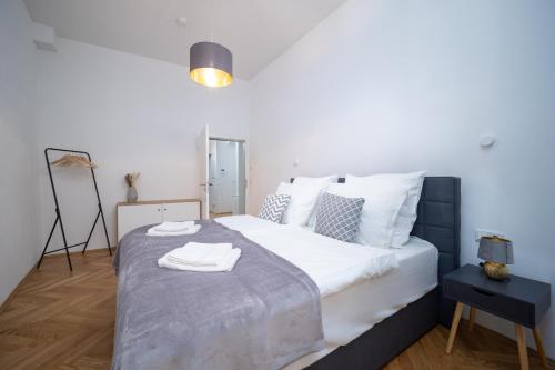 包岑CoView - Bautzen - Design Apartment in der Altstadt mit fantastischem Ausblick的卧室配有带毛巾的大型白色床