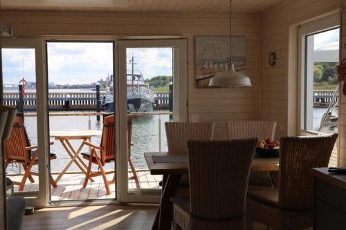 施特拉尔松德Hausboot Liliput的一间带桌椅和船只的用餐室