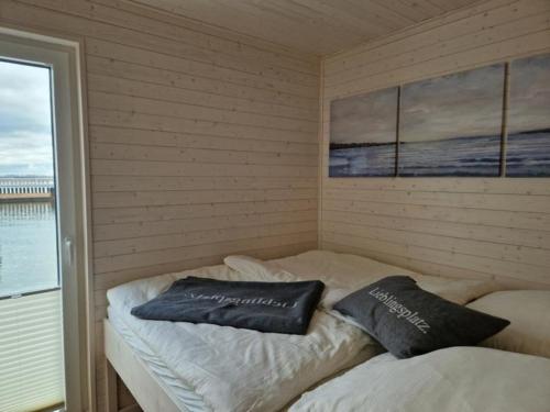 施特拉尔松德Hausboot Liliput的两个枕头坐在房间里的床边