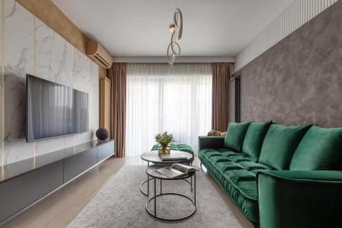 布加勒斯特Urbanstay Suites - Prime Location Designer Suite的客厅配有绿色沙发和桌子