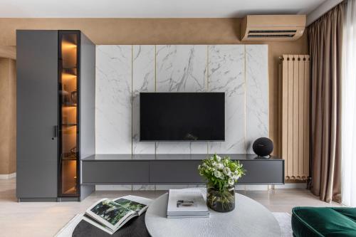 布加勒斯特Urbanstay Suites - Prime Location Designer Suite的客厅的墙上配有电视